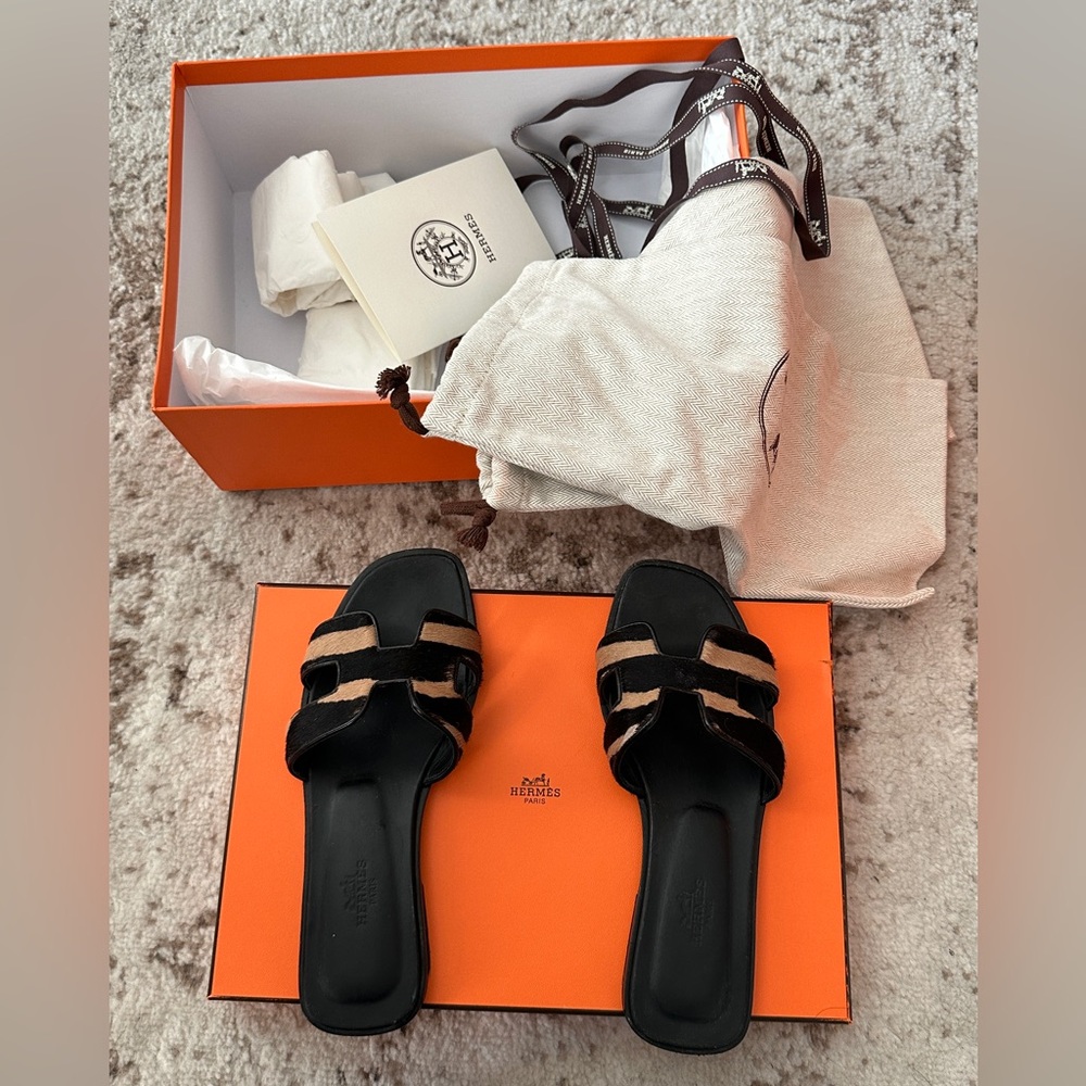 Hermes Oran Noir/BeigeSandal in moire calfskin with iconic "H" cut-out.